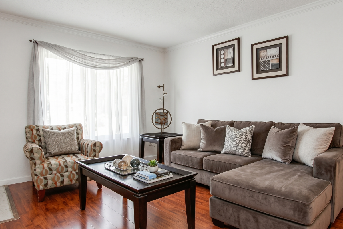 Furnished living room with hardwood floors at Falls of Westpark apartment in Houston, TX