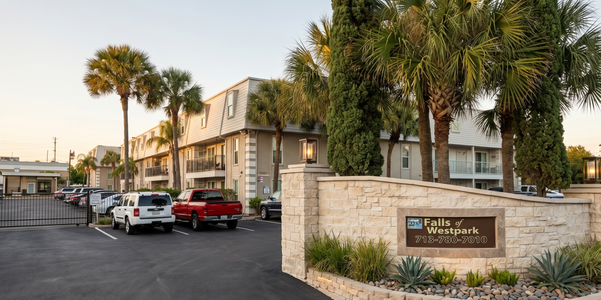 Entrance monument sign and building exterior at Falls of Westpark apartments in Houston, TX